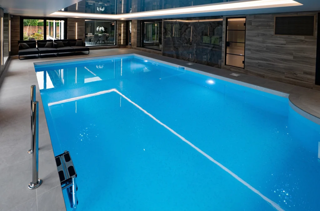 Luxury indoor swimming pool with modern architecture and lounging area