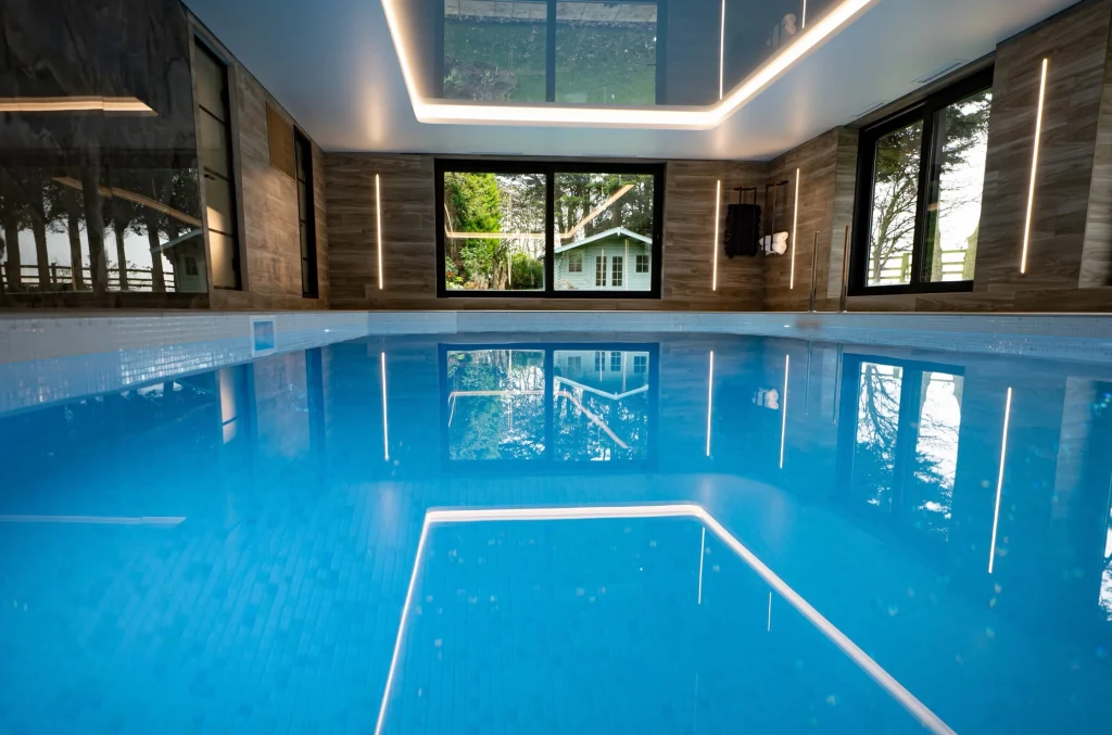 Modern indoor swimming pool with wooden walls and skylights