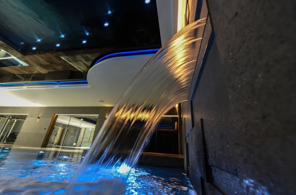 Illuminated waterfall cascading into glowing blue pool